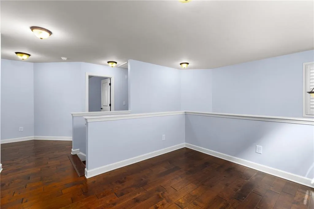 Empty room with dark wood-type flooring