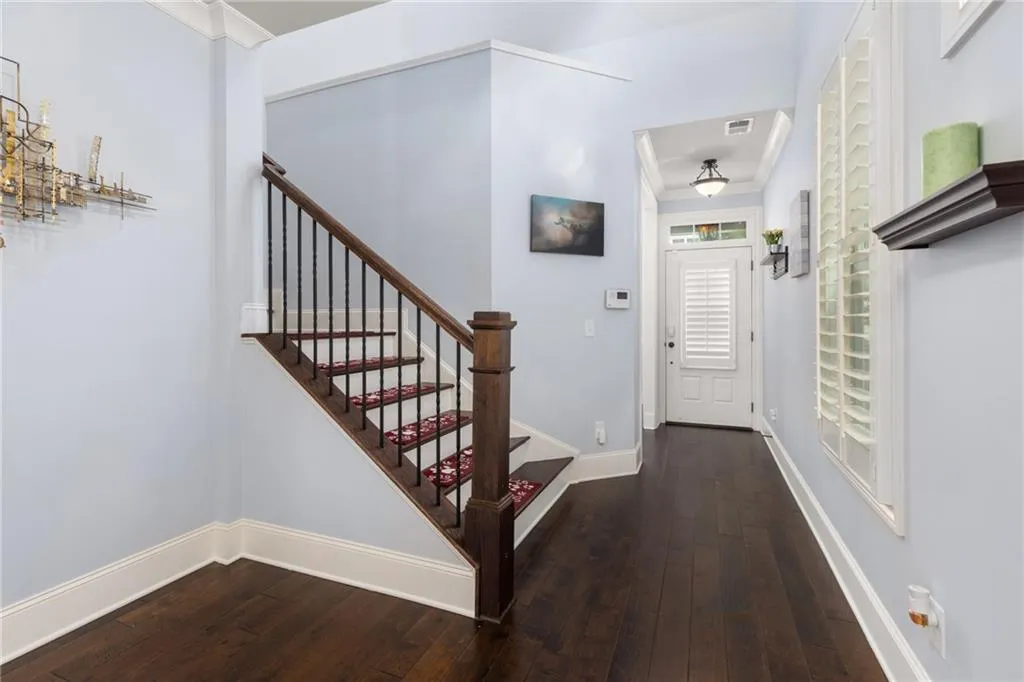 Foyer with dark hardwood / wood-style floors and crown molding