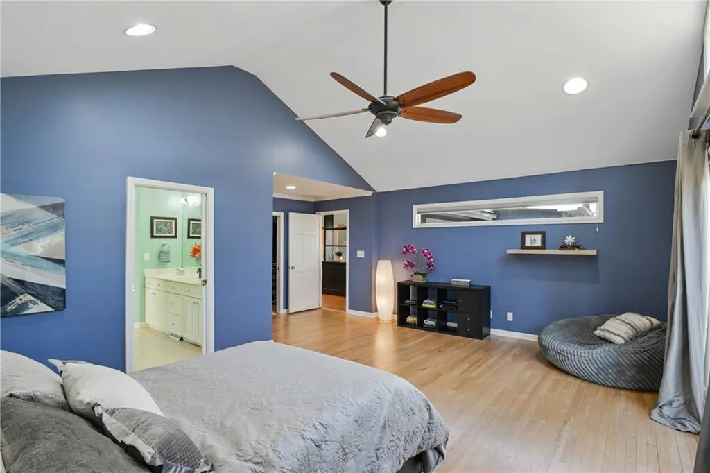 Bedroom with high vaulted ceiling, recessed lighting, wood finished floors, and baseboards