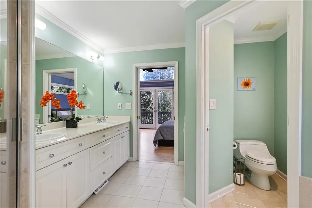 Ensuite bathroom with visible vents, toilet, ornamental molding, a sink, and tile patterned floors