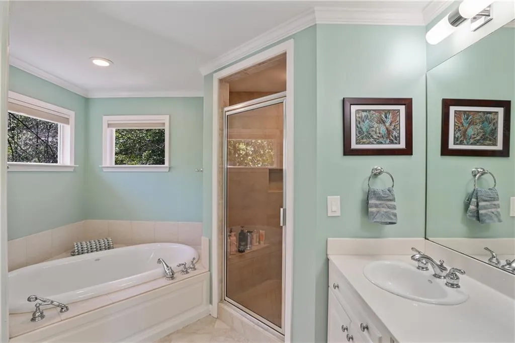 Bathroom featuring a garden tub, a shower stall, and ornamental molding