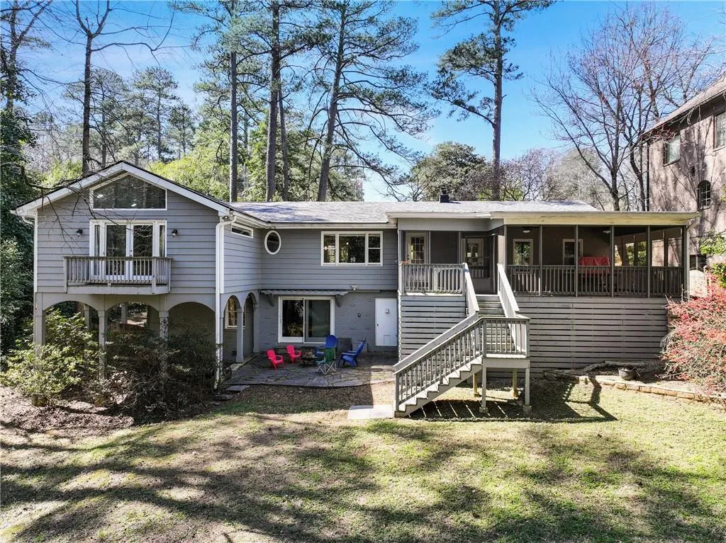View of back of the home with terrace level a sunroom, and a patio.