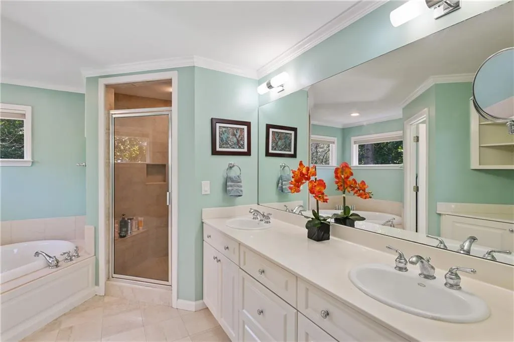 Full bathroom featuring a bath, crown molding, and a sink