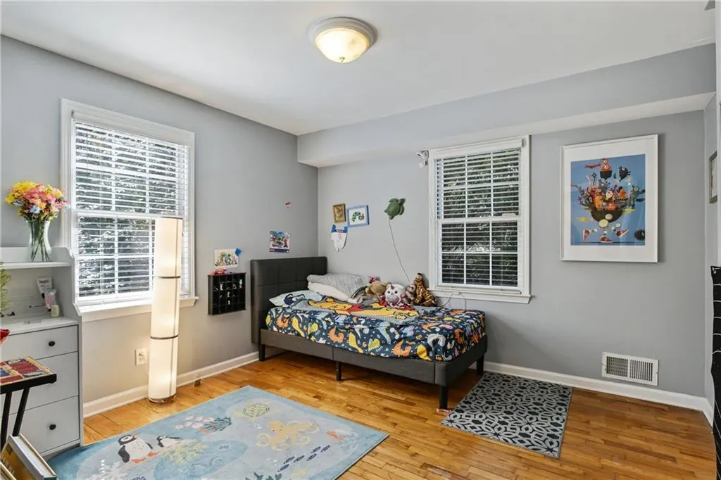 Bedroom featuring light wood finished floors, baseboards, and visible vents