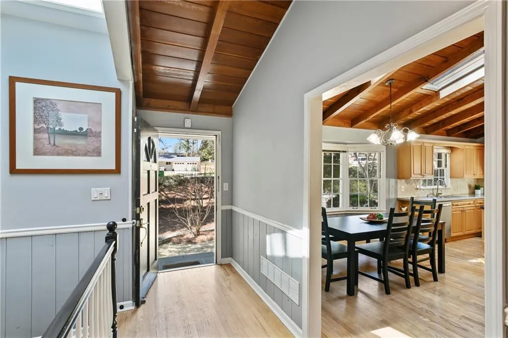 Doorway with wood ceiling, visible vents, a sink, and wainscoting