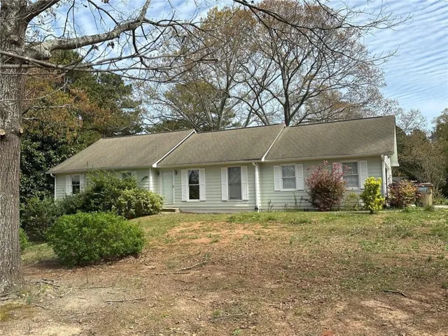 Light green horizontal siding with white window shutters