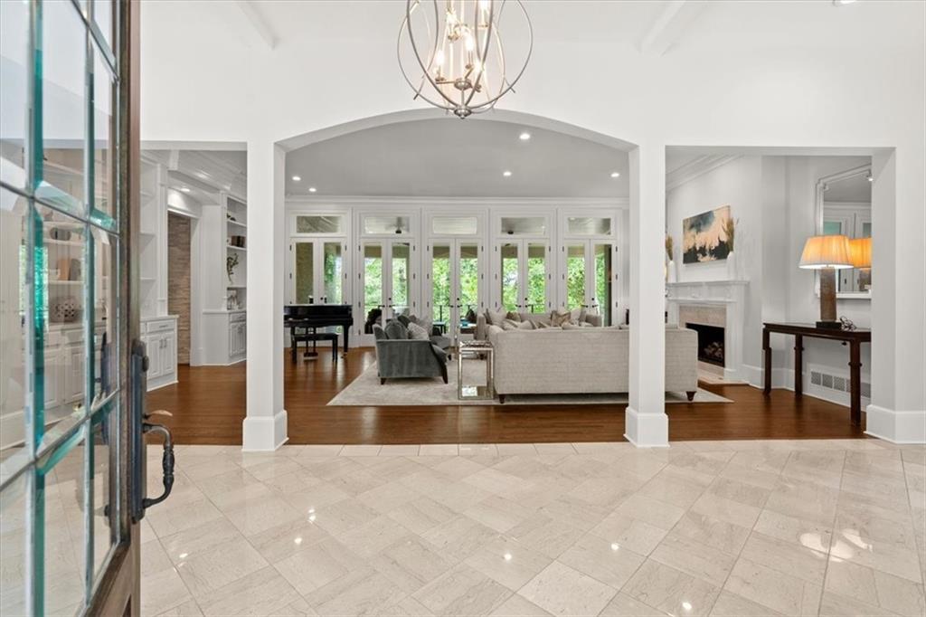 Tiled foyer with a notable chandelier and beam ceiling Tiled foyer with a notable chandelier and beam ceiling