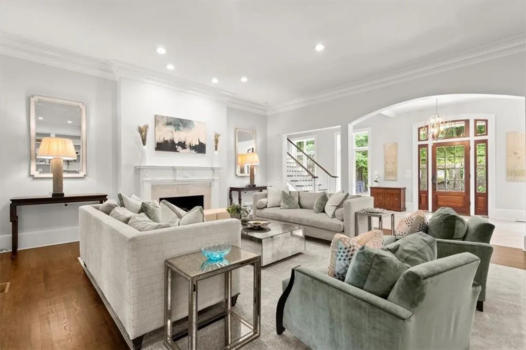 Living room featuring ornamental molding, a notable chandelier, and dark wood-type flooring Living room featuring ornamental molding, a notable chandelier, and dark wood-type flooring