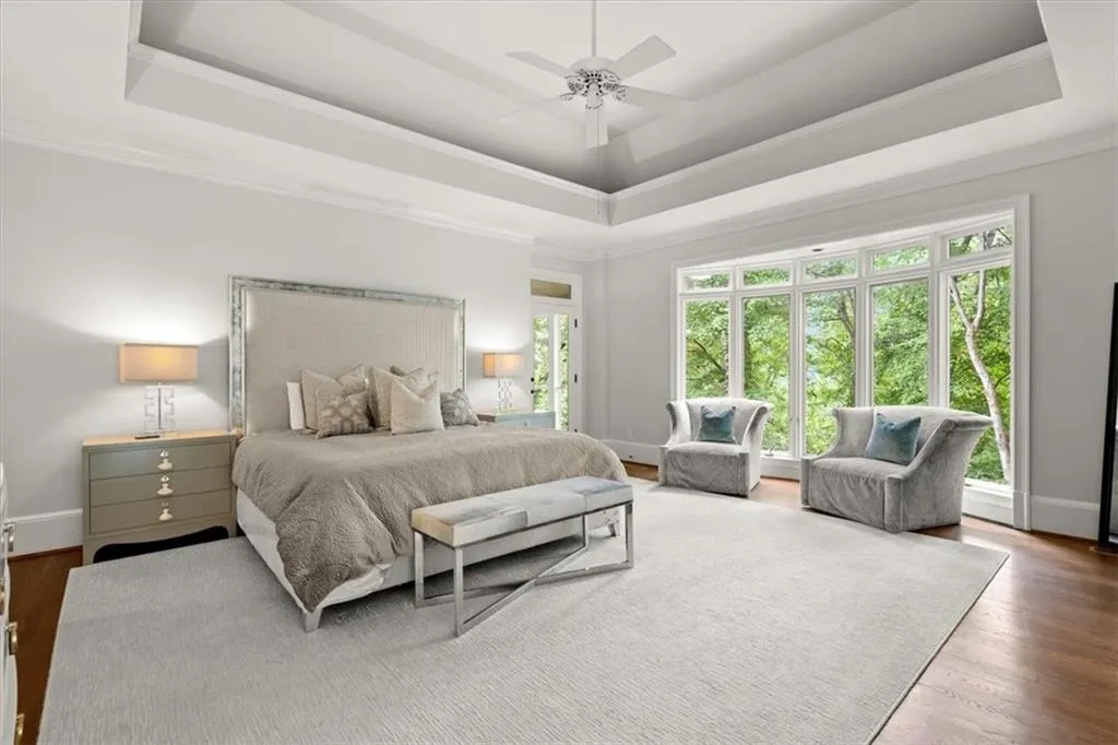 Bedroom featuring hardwood / wood-style floors, a raised ceiling, crown molding, and ceiling fan Bedroom featuring hardwood / wood-style floors, a raised ceiling, crown molding, and ceiling fan