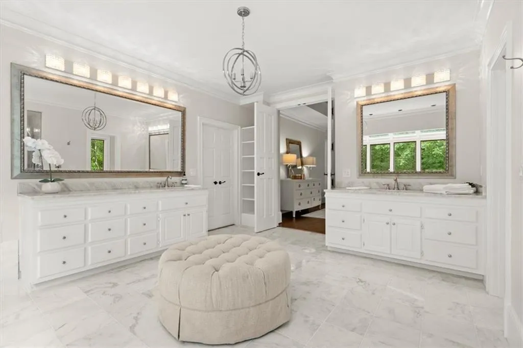 Bathroom featuring an inviting chandelier, crown molding, vanity, and tile flooring Bathroom featuring an inviting chandelier, crown molding, vanity, and tile flooring