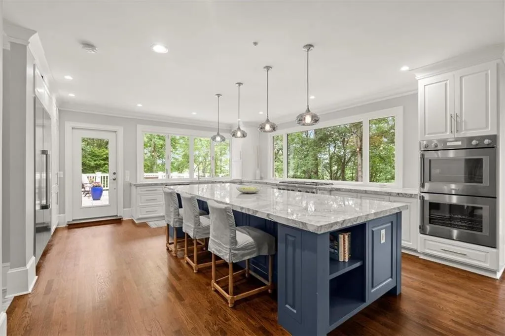 Kitchen featuring double oven, white cabinets, and a center island Kitchen featuring double oven, white cabinets, and a center island