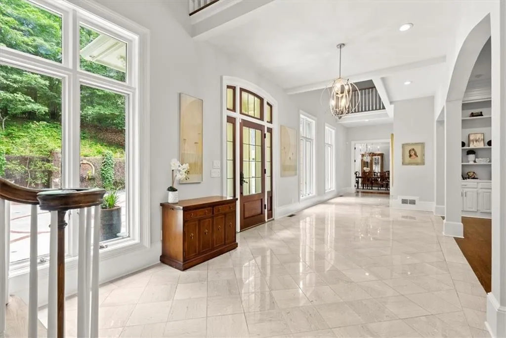 Tiled entryway featuring plenty of natural light, a towering ceiling, french doors, and a notable chandelier Tiled entryway featuring plenty of natural light, a towering ceiling, french doors, and a notable chandelier
