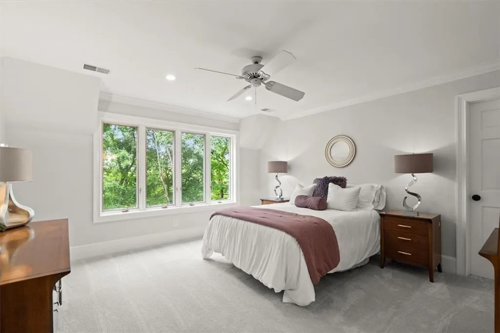 Carpeted bedroom featuring ornamental molding and ceiling fan Carpeted bedroom featuring ornamental molding and ceiling fan