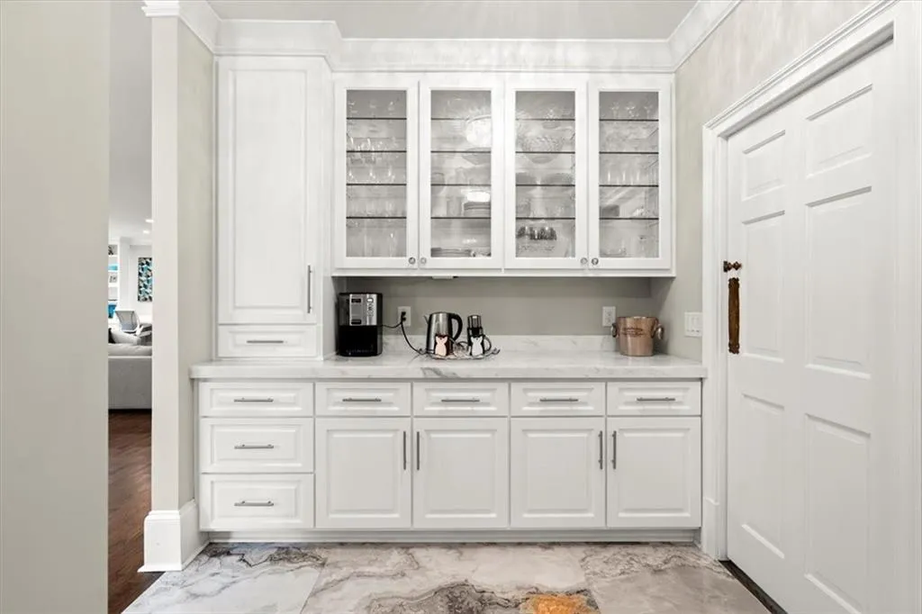 Bar with white cabinets, light stone countertops, and light hardwood / wood-style flooring Bar with white cabinets, light stone countertops, and light hardwood / wood-style flooring