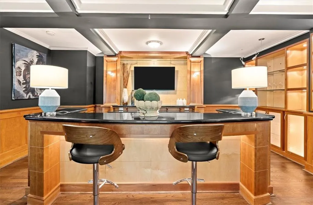 Bar with wood flooring, crown molding, and coffered ceiling Bar with wood flooring, crown molding, and coffered ceiling