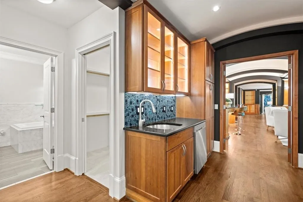 Bar with dishwasher, sink, light wood-type flooring, and backsplash Bar with dishwasher, sink, light wood-type flooring, and backsplash