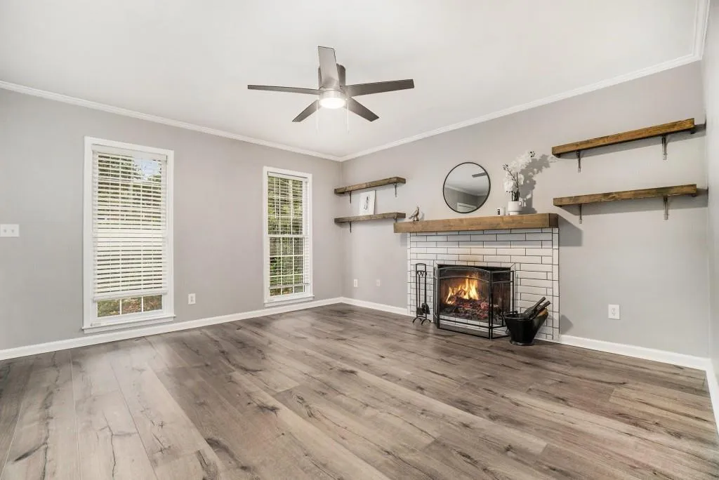 The Open-Concept Living and Dining Area feels bright and inviting with a Fireside Feature Wall, Floating Shelves, and plenty of Natural Light.