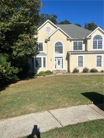 View of front of house with stucco siding and a front lawn
