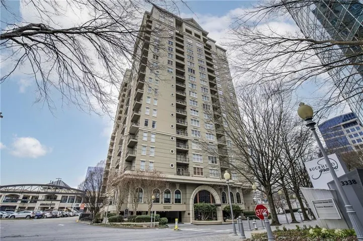 High-rise building with multiple balconies and an arched entrance