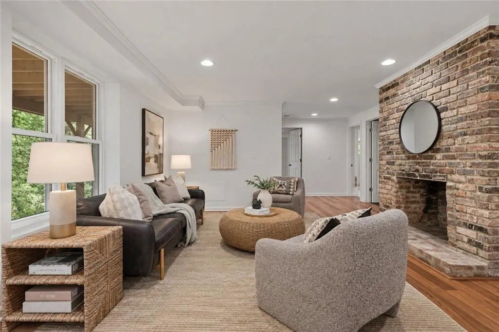 Living area featuring a floor-to-ceiling brick fireplace, wood-finish flooring, recessed lighting, and multi-pane windows
