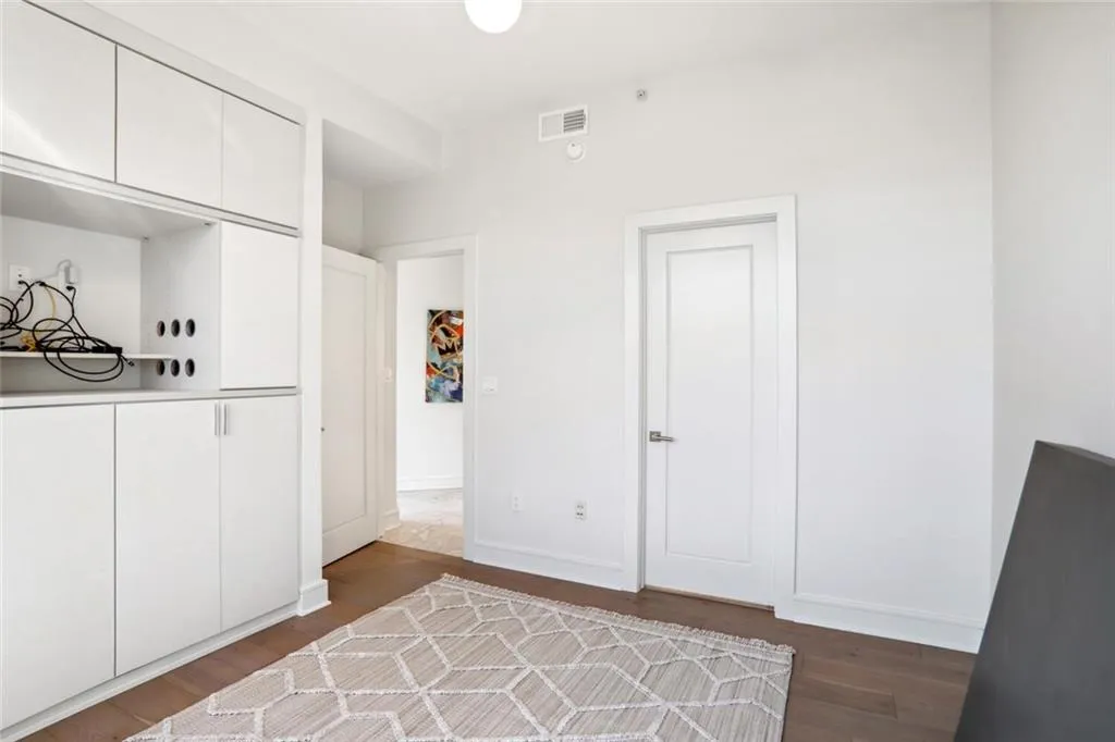Bedroom with visible vents, baseboards, and wood finished floors