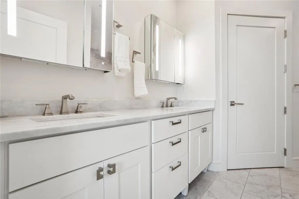 Bathroom featuring marble finish floor, double vanity, and a sink