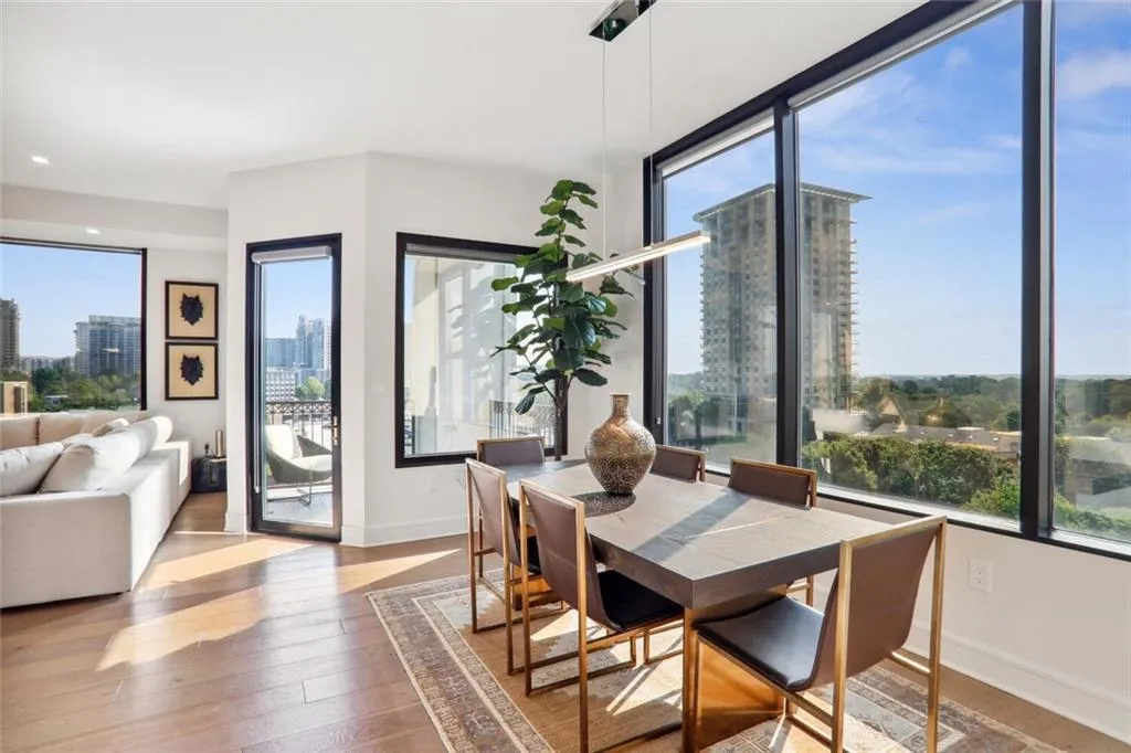 Dining room with a wealth of natural light, a city view, baseboards, and hardwood / wood-style flooring