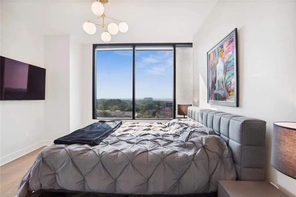 Bedroom with a notable chandelier, wood finished floors, and baseboards