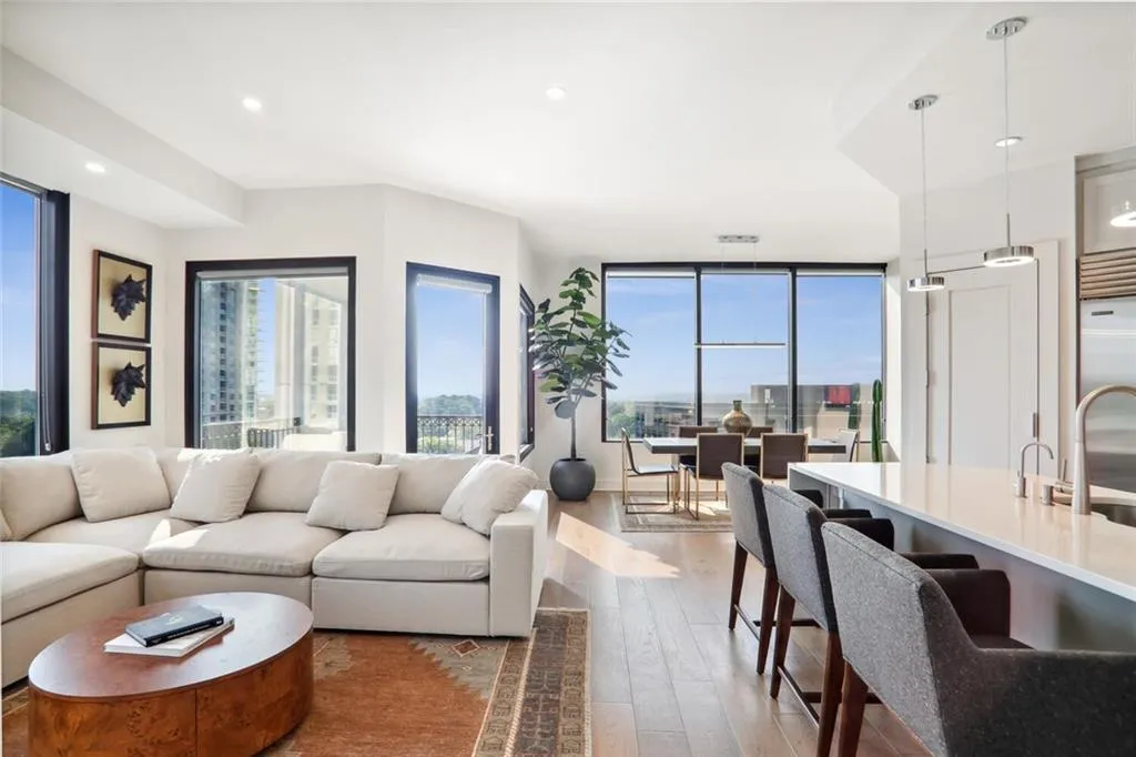 Living room featuring floor to ceiling windows, wood finished floors, and recessed lighting