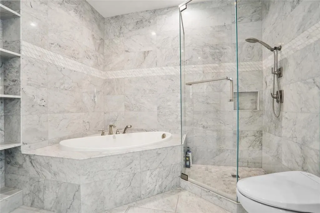 Bathroom featuring a stall shower, tile walls, toilet, and a bath