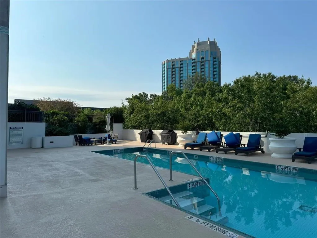 Community pool with a patio area and fence