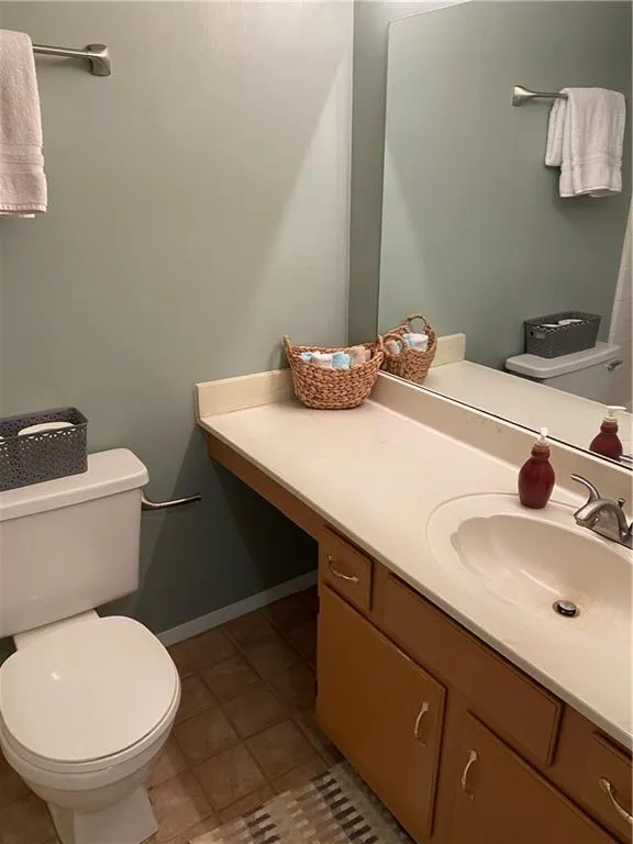 Bathroom featuring toilet, oversized vanity, and tile flooring