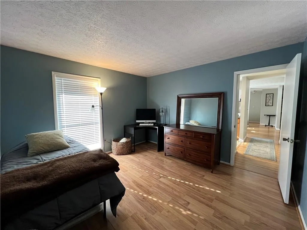 Bedroom featuring light hardwood / wood-style flooring and a textured ceiling