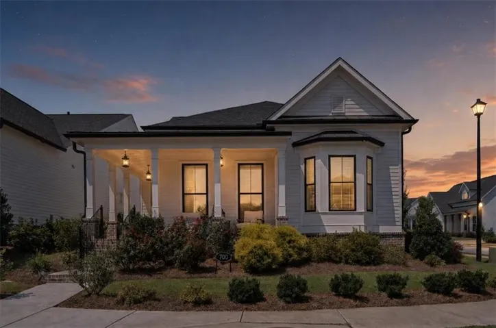 White siding exterior with a covered front porch, dark-framed windows, and a bay window feature