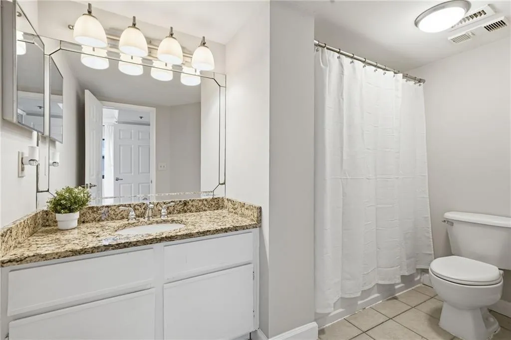 Full bath featuring vanity and light tile patterned flooring
