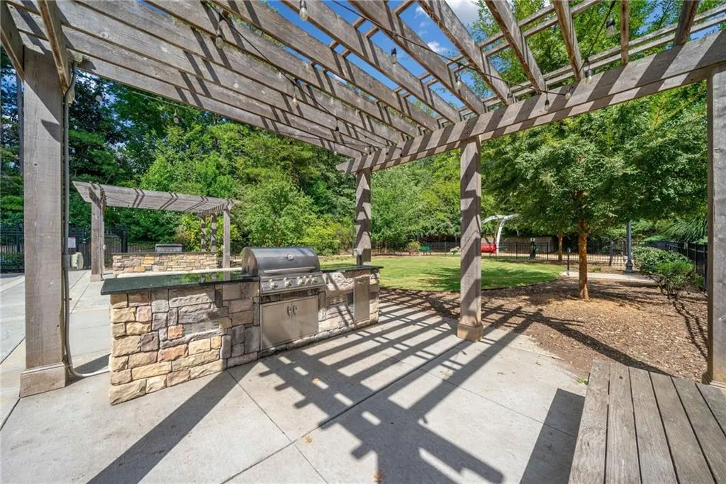 Fenced backyard featuring a pergola, exterior kitchen, and a patio