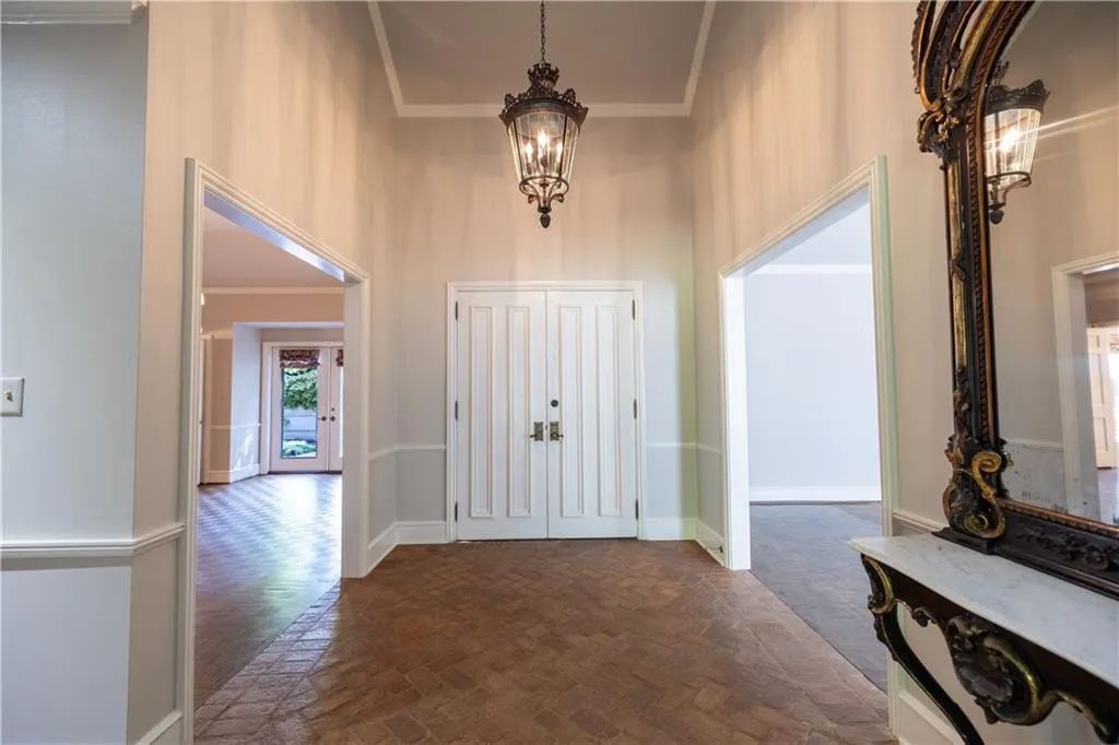 Entryway with a high ceiling, crown molding, and a chandelier
