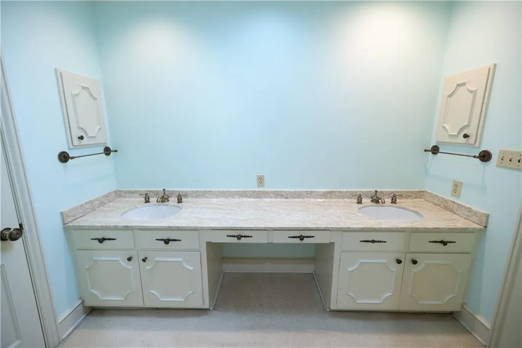 Bathroom with double vanity and baseboards