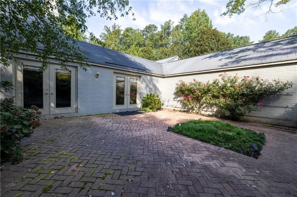 Back of house with french doors, a patio, brick siding, and roof with shingles