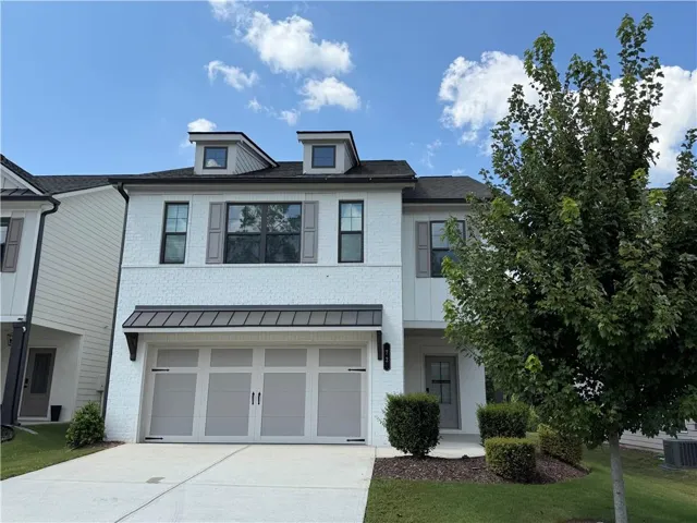 White brick facade with dark-framed windows and gray shutters