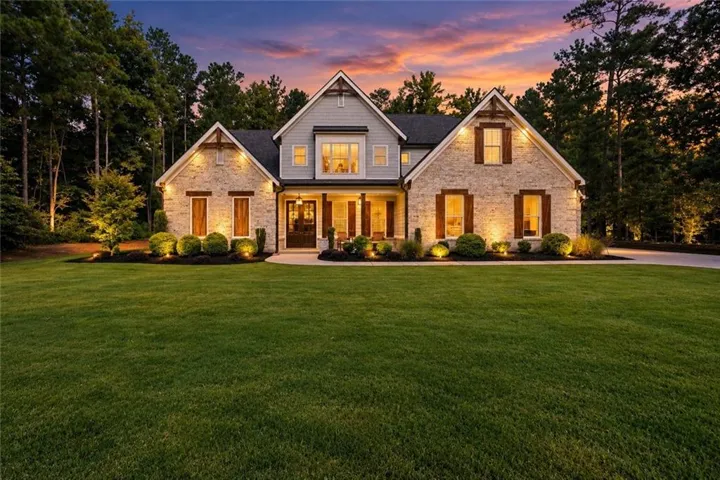 Stone and siding exterior with dark shutters, gabled rooflines, and a covered porch