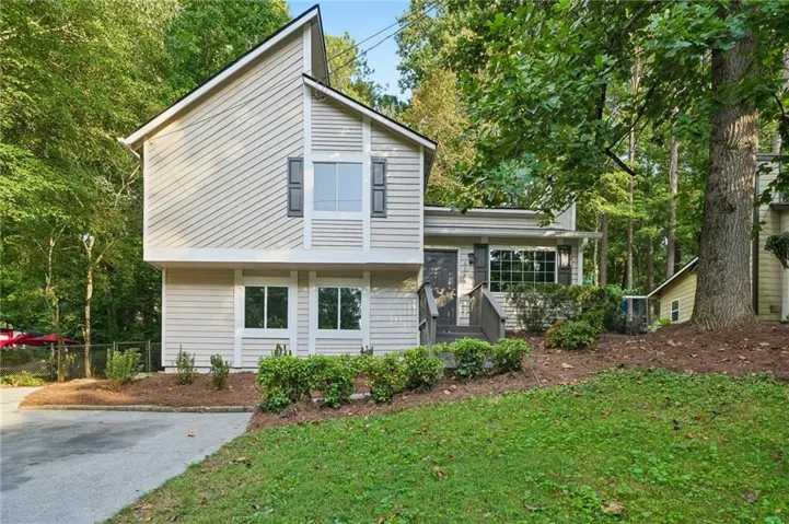 Multi-level exterior with light-toned siding and dark shutters