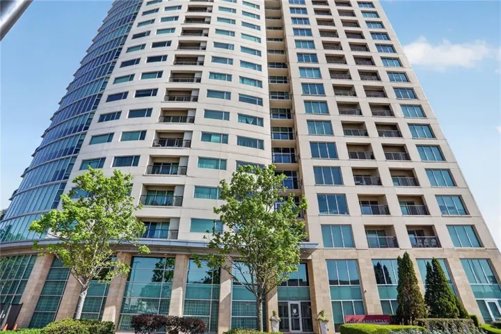 High-rise building with a curved glass facade and multiple private balconies