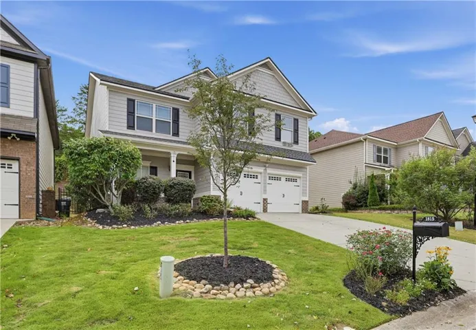 Two-story residence with light gray siding and dark shutters