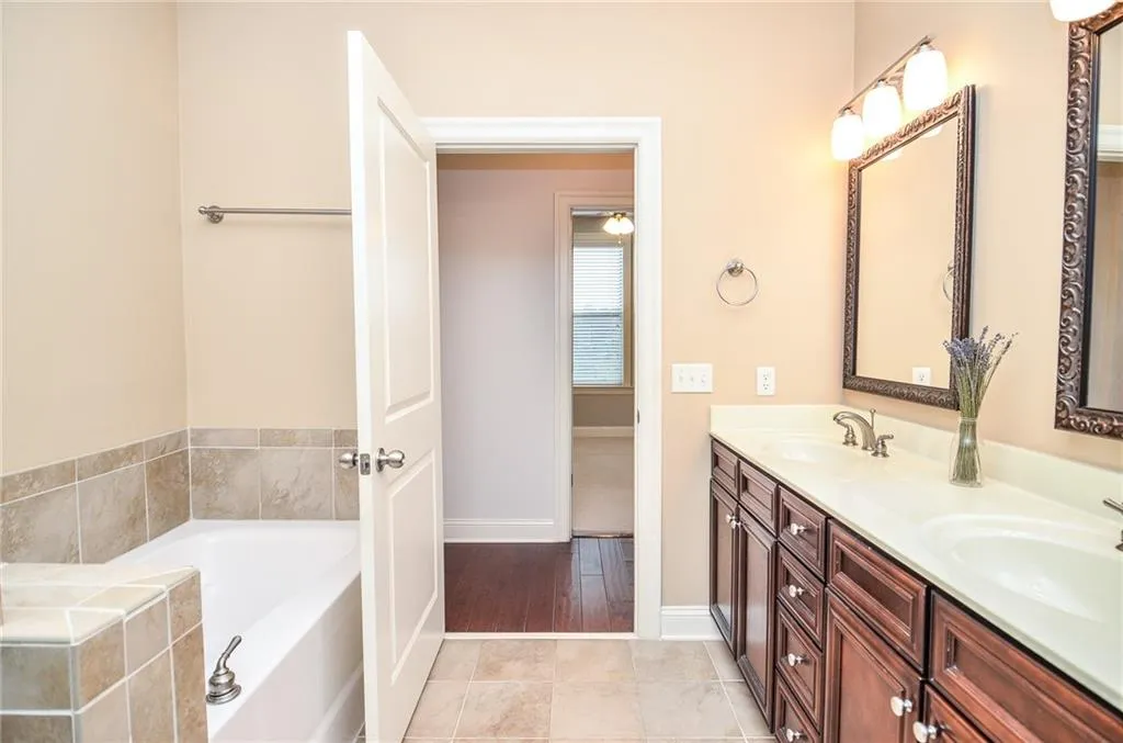 Bathroom featuring vanity, tile patterned floors, and a washtub