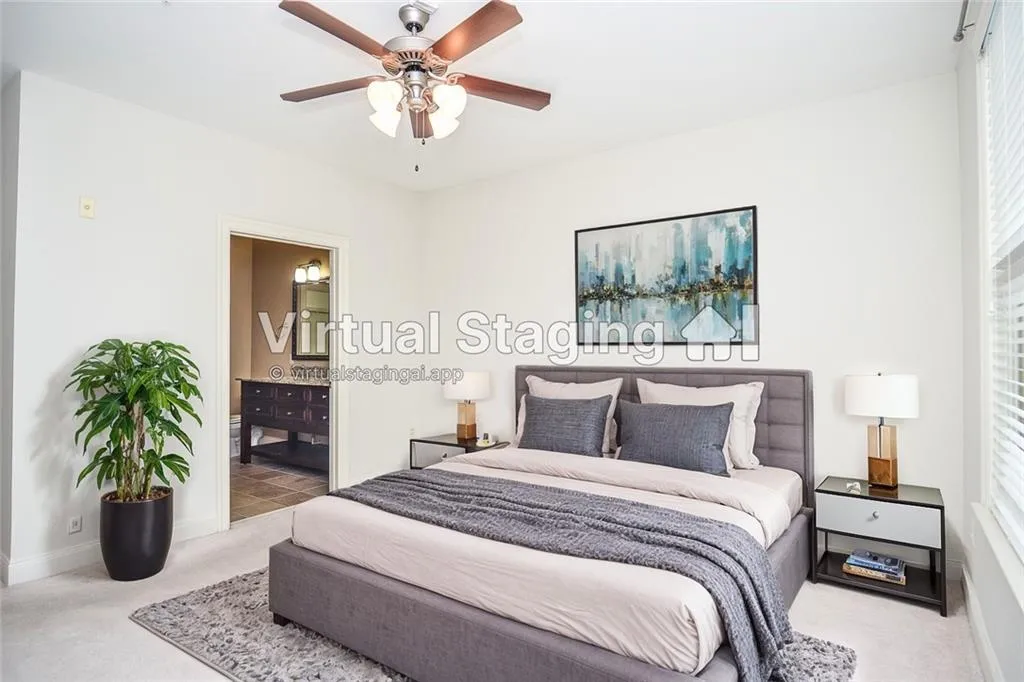 Carpeted bedroom with connected bathroom, ceiling fan, and multiple windows