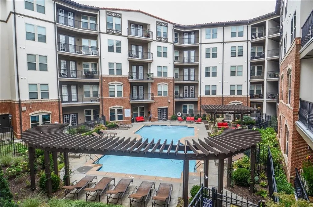 View of pool with pool water feature and a pergola