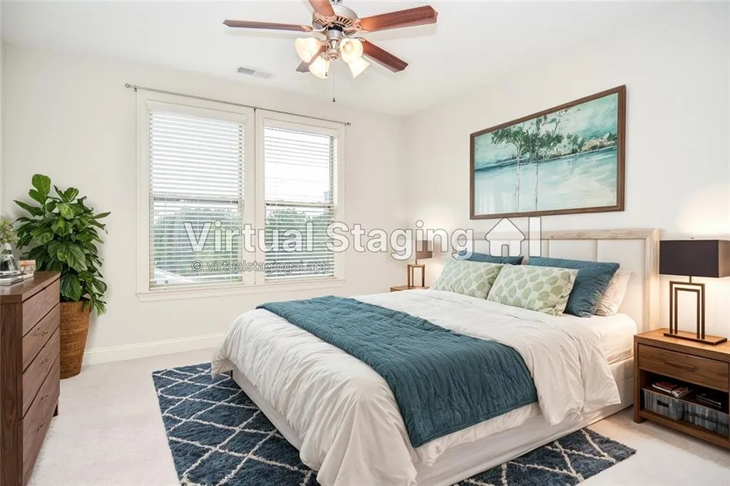 Bedroom with ceiling fan and light colored carpet