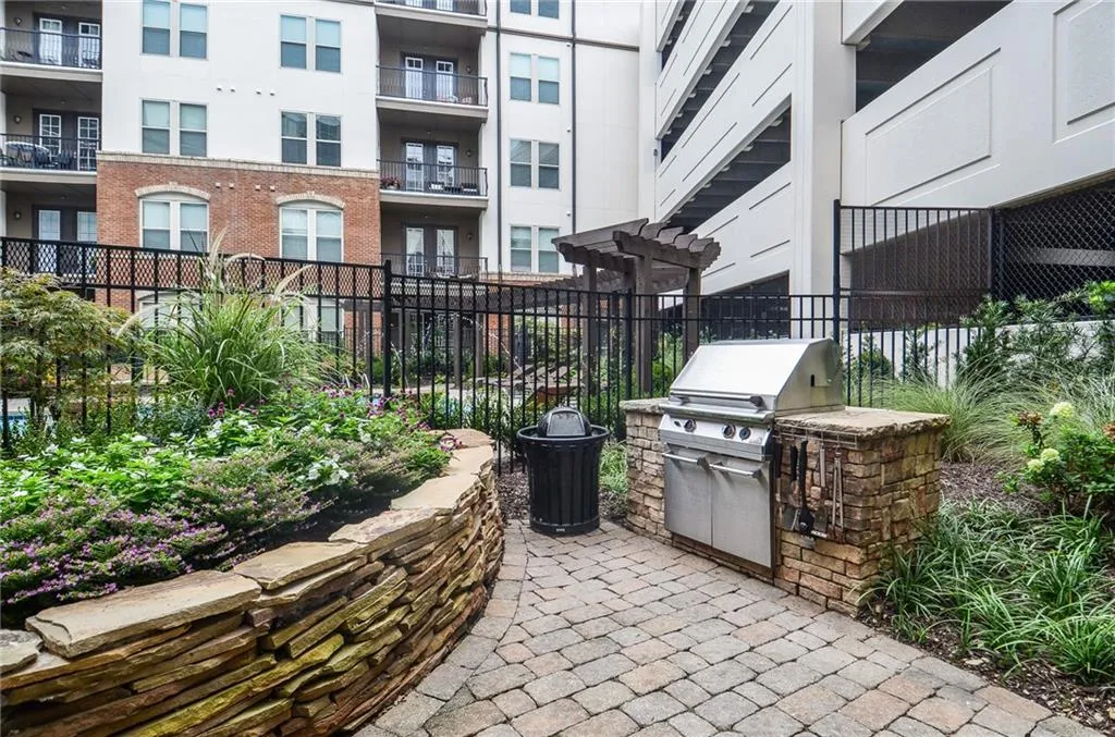 View of patio featuring area for grilling and a balcony