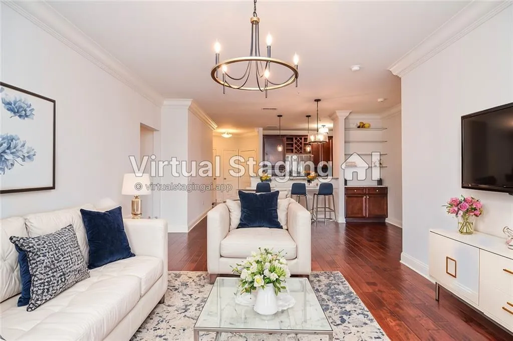 Living room with ornamental molding, an inviting chandelier, and dark hardwood / wood-style flooring